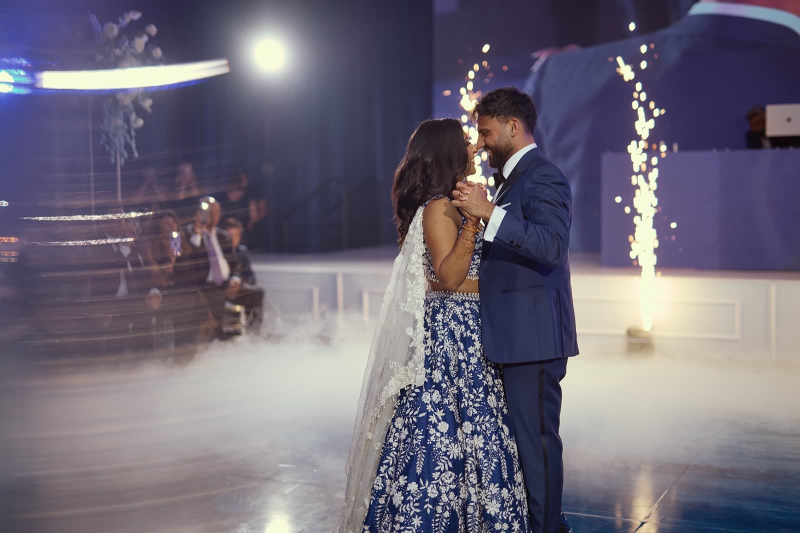 Couple sharing a first dance in low-lying fog between two cold-spark fountains